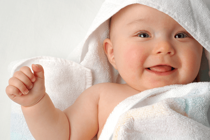 Parent giving gentle first bath to newborn baby